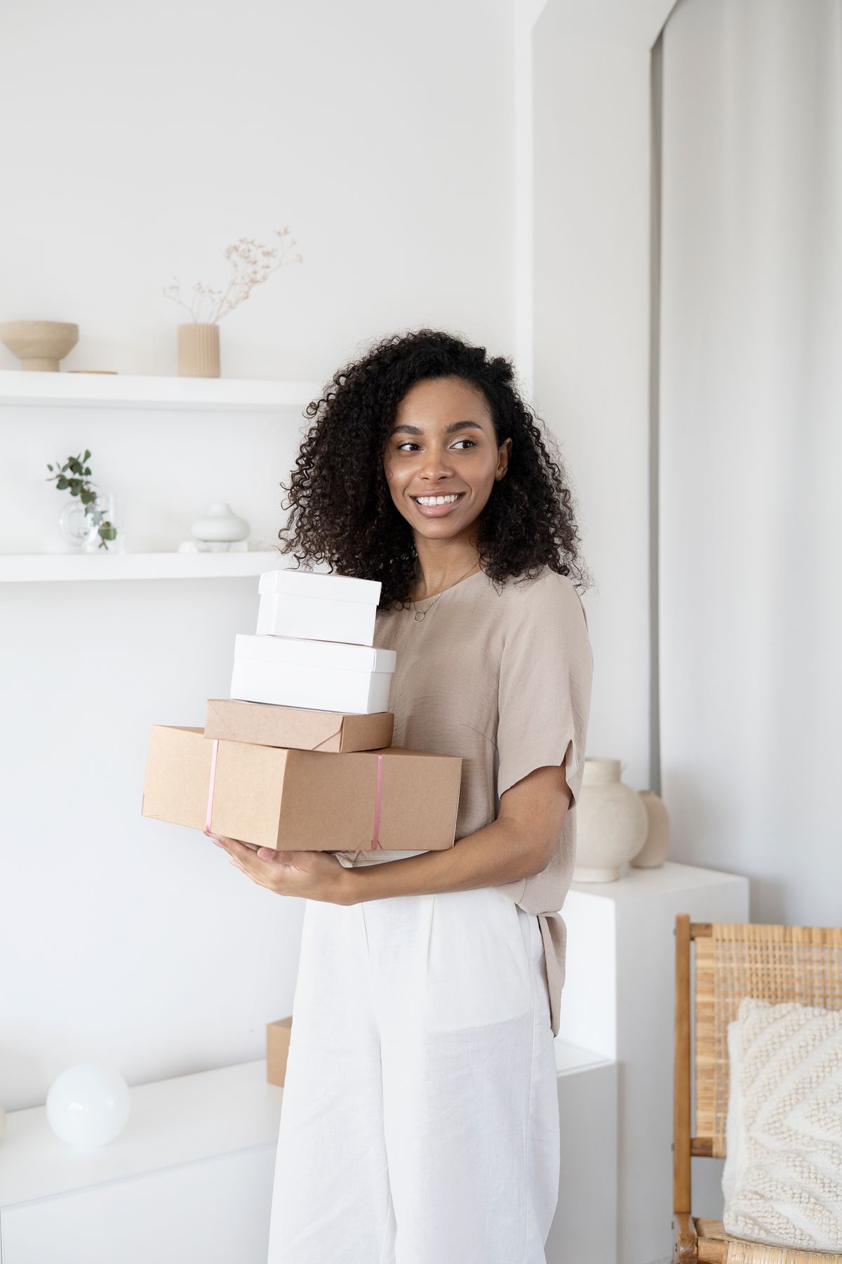 Webshop-eigenaar met een stapel dozen in een lichte werkkamer
